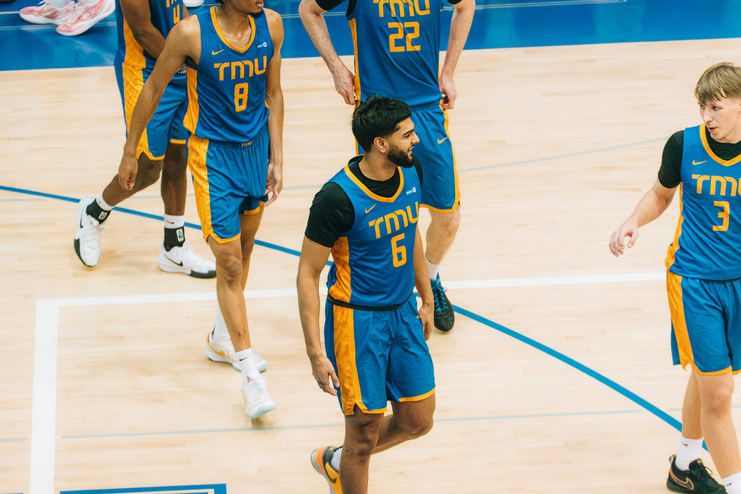 The TMU Bold men's basketball team coming onto the court after a stoppage of play