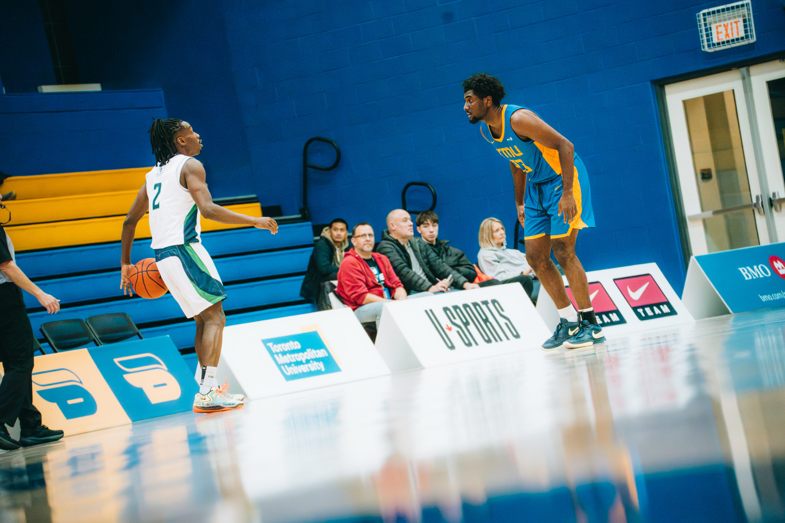 A TMU player guarding a Nippising player with the ball at the Mattamy Athletics Centre