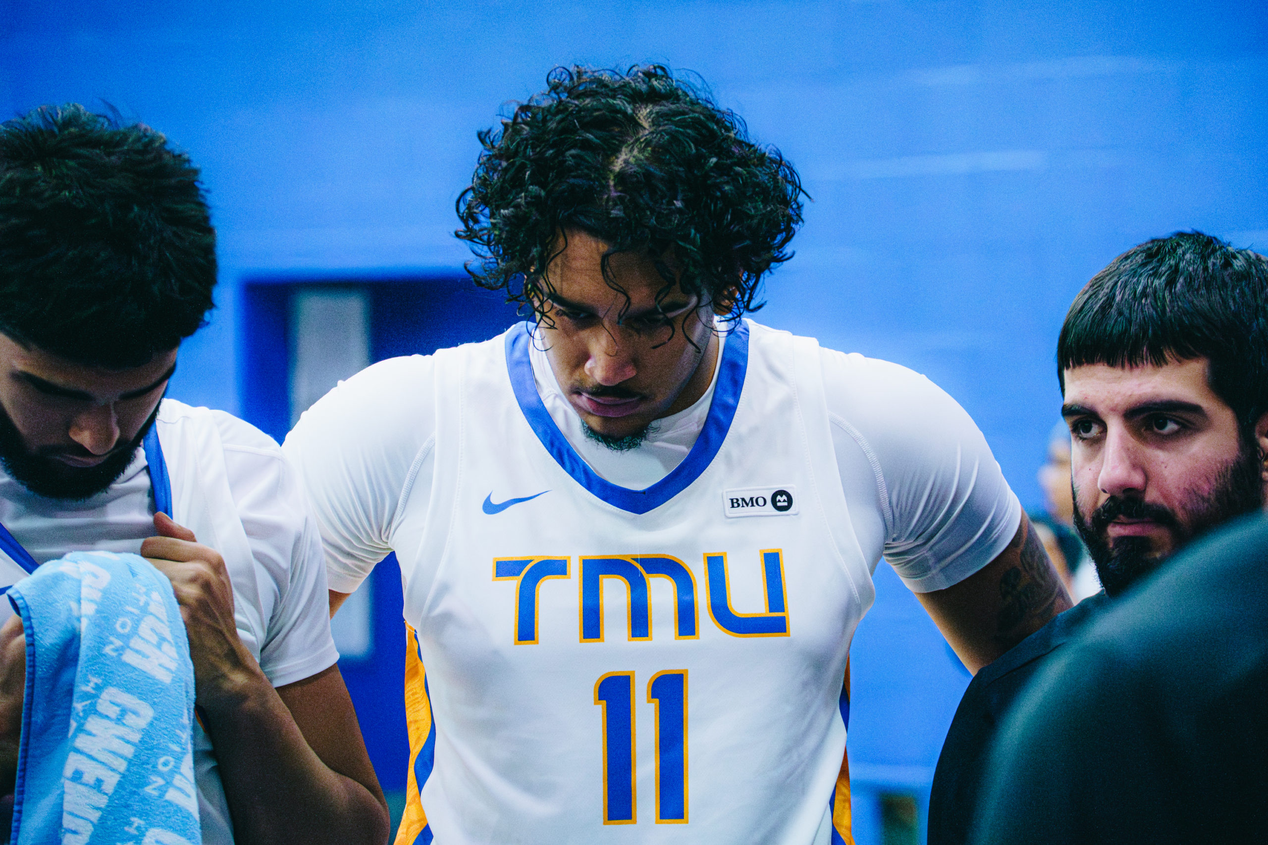 A TMU player looks toward his coach during a team huddle