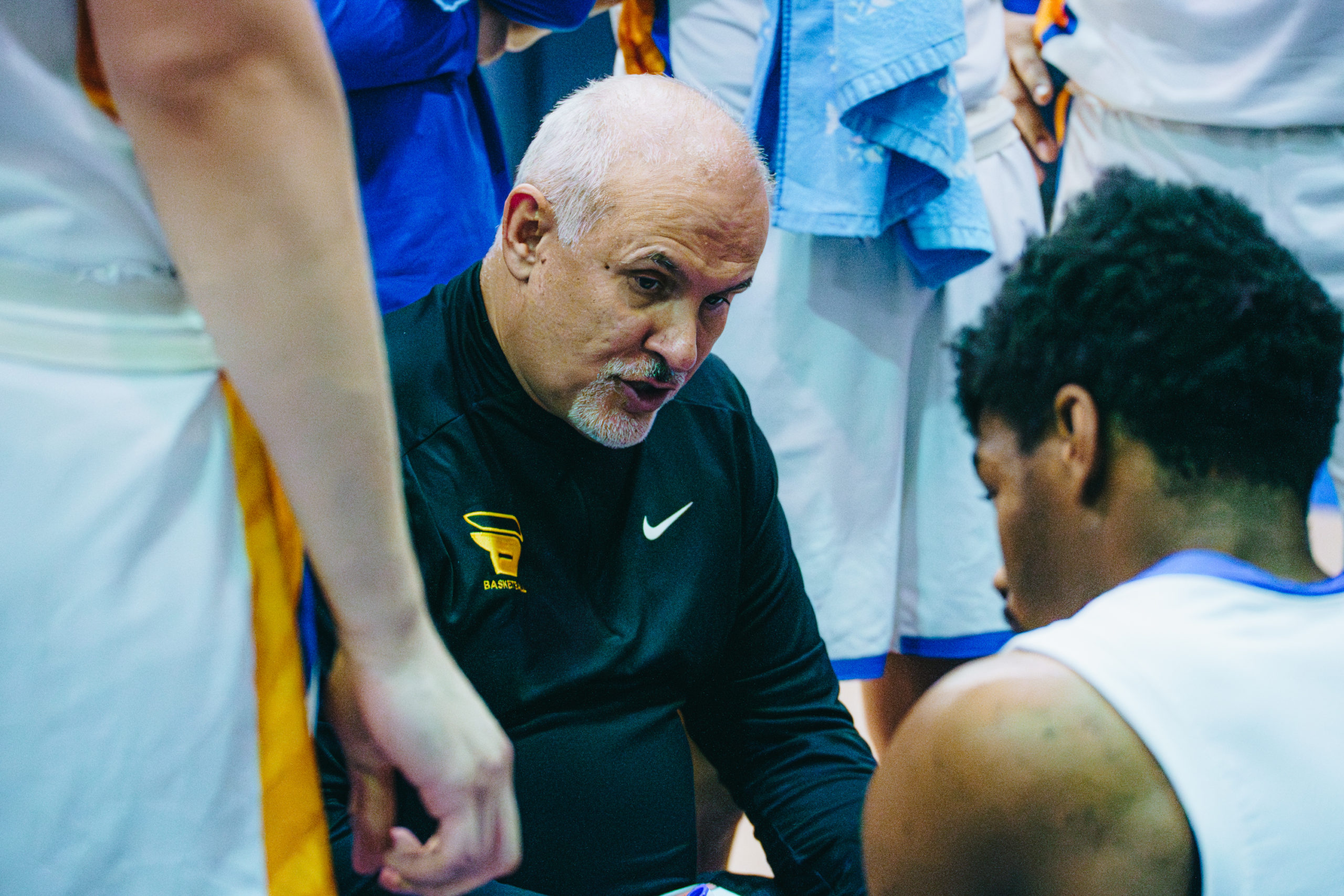 Head coach David DeAveiro leads his team in a huddle