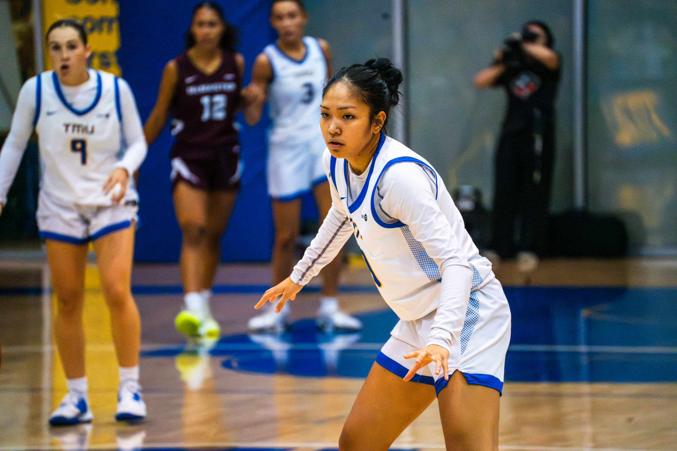 A women's basketball player defends her court