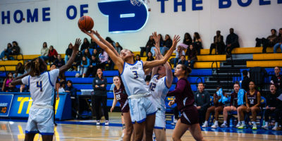 A women's basketball player attempts to gain possession