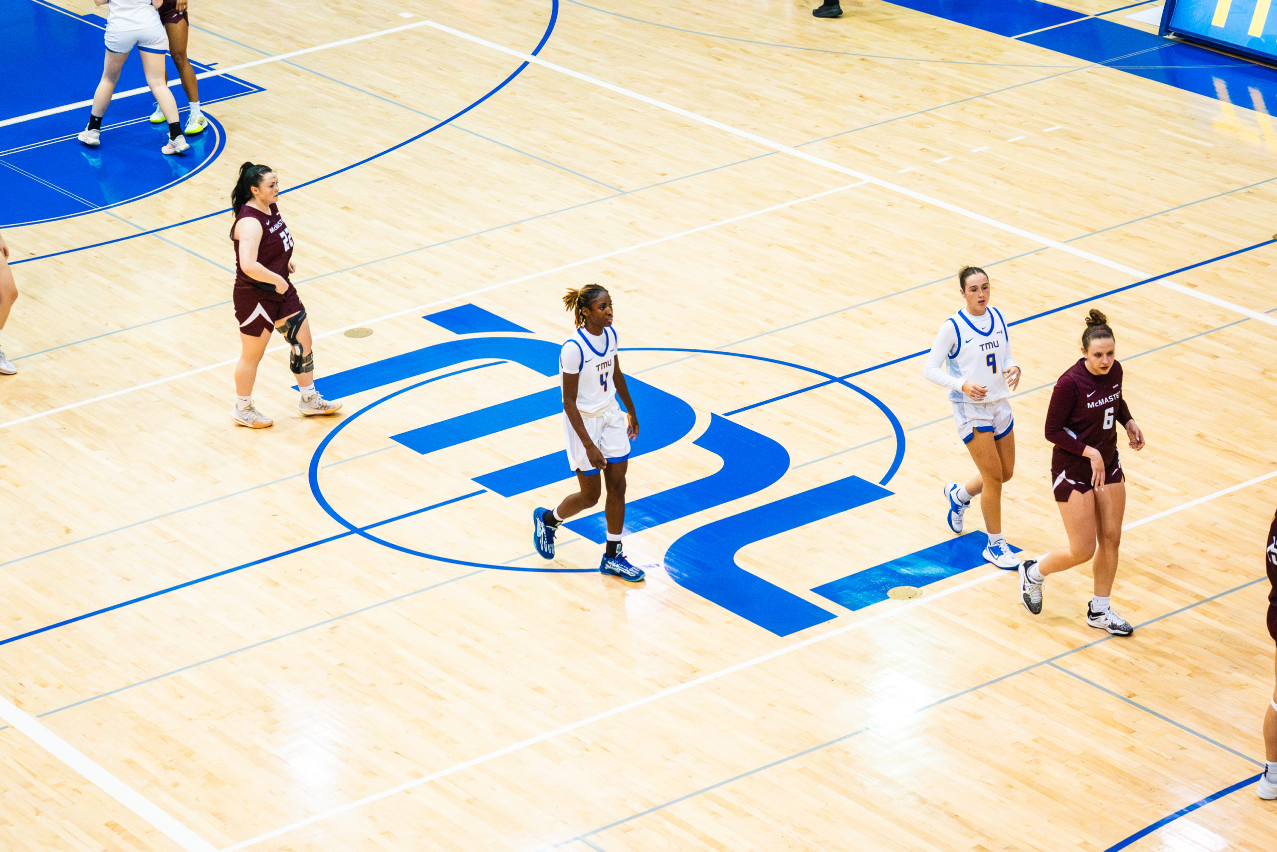 TMU and McMaster walk along the court