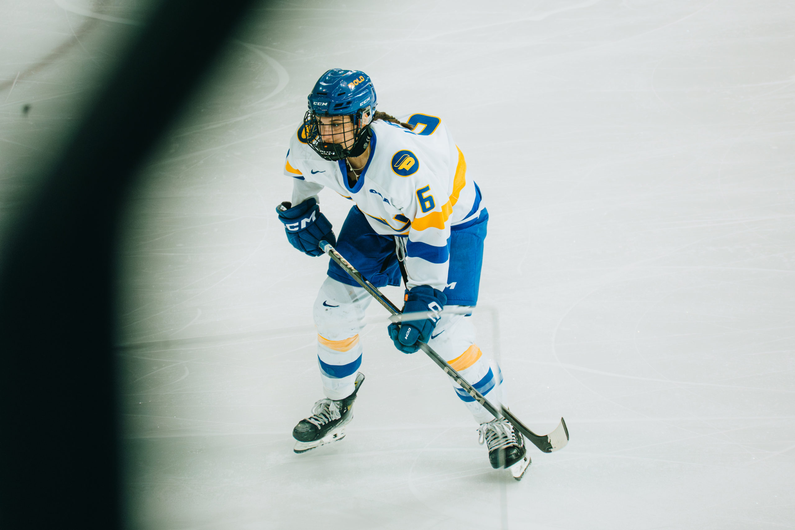 A TMU women's hockey player in a defencive stance during a play at the Mattamy Athletics Centre