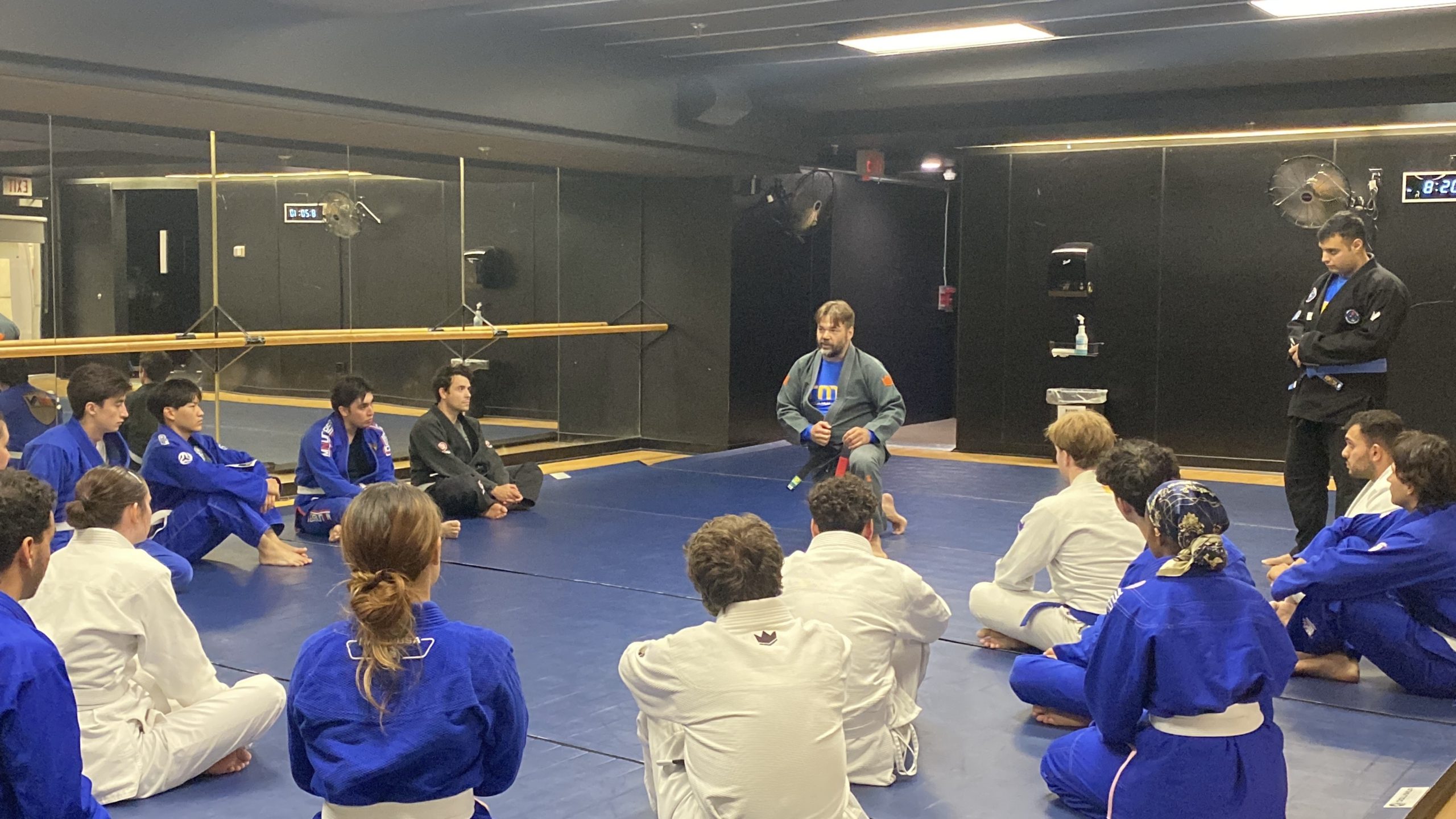 TMU's Brazilian Jiu-Jitsu club kneels in a circle during a practice
