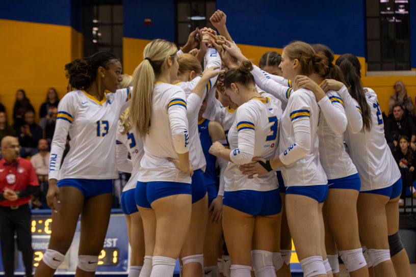 The TMU Bold women's volleyball team in a huddle before a game at the Mattamy Athletics Centre