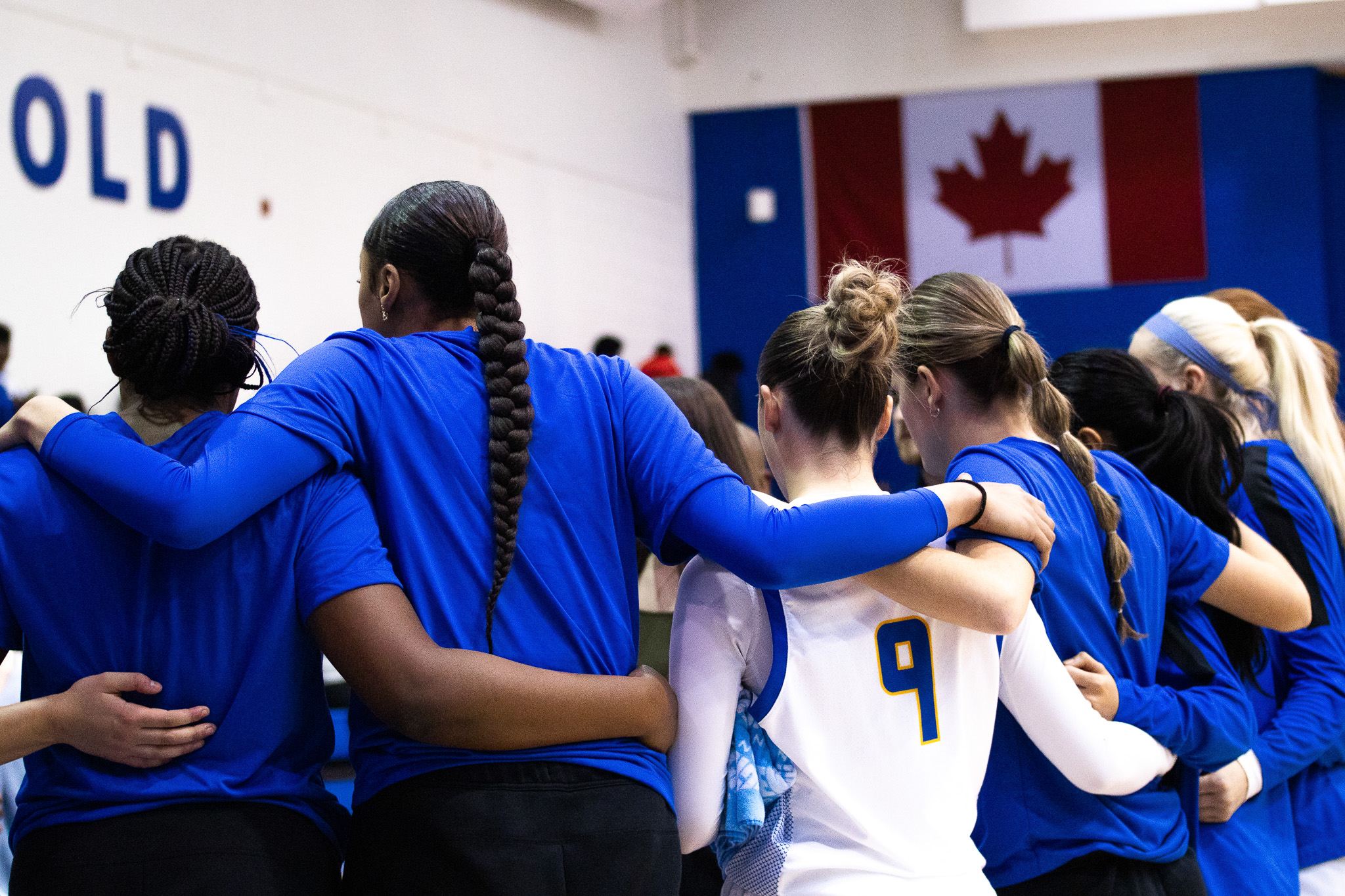 TMU women's basketball huddling on the court during a stoppage of play at the Mattamy Athletics Centre