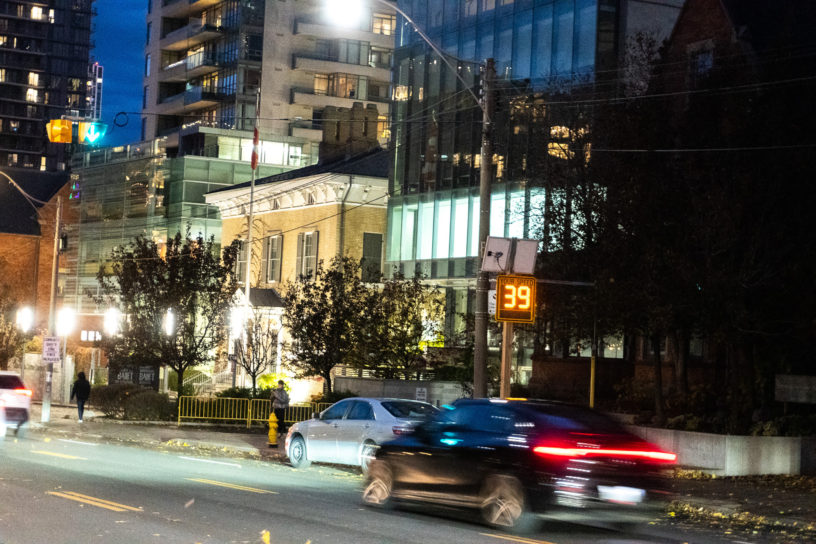 Image of cars driving down the street with a speedometer that reads "39 km/h".