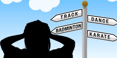 Person looking at a directional sign which reads "Track", "Dance", "Badminton" and "Karate".