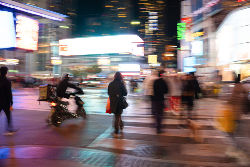 Blurry image of people crossing the street at the Yonge and Dundas intersection.