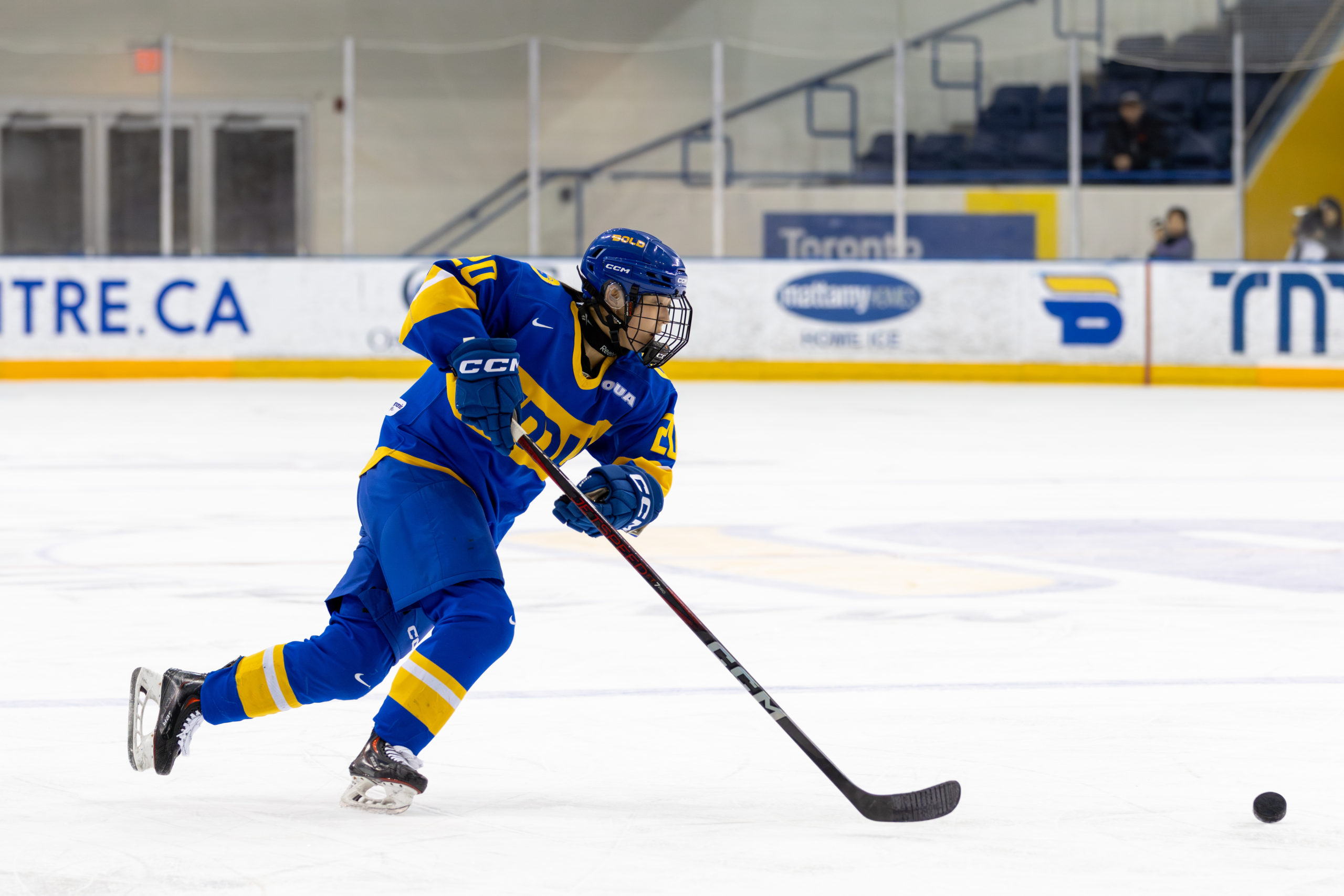 TMU Bold women's hockey player chasing a puck at the Mattamy Athletics Centre 