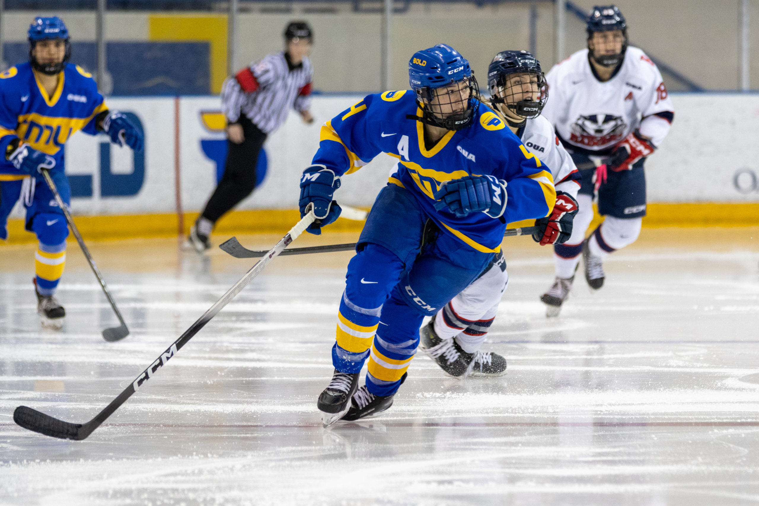 TMU Bold women's hockey player chasing a puck at the Mattamy Athletics Centre 