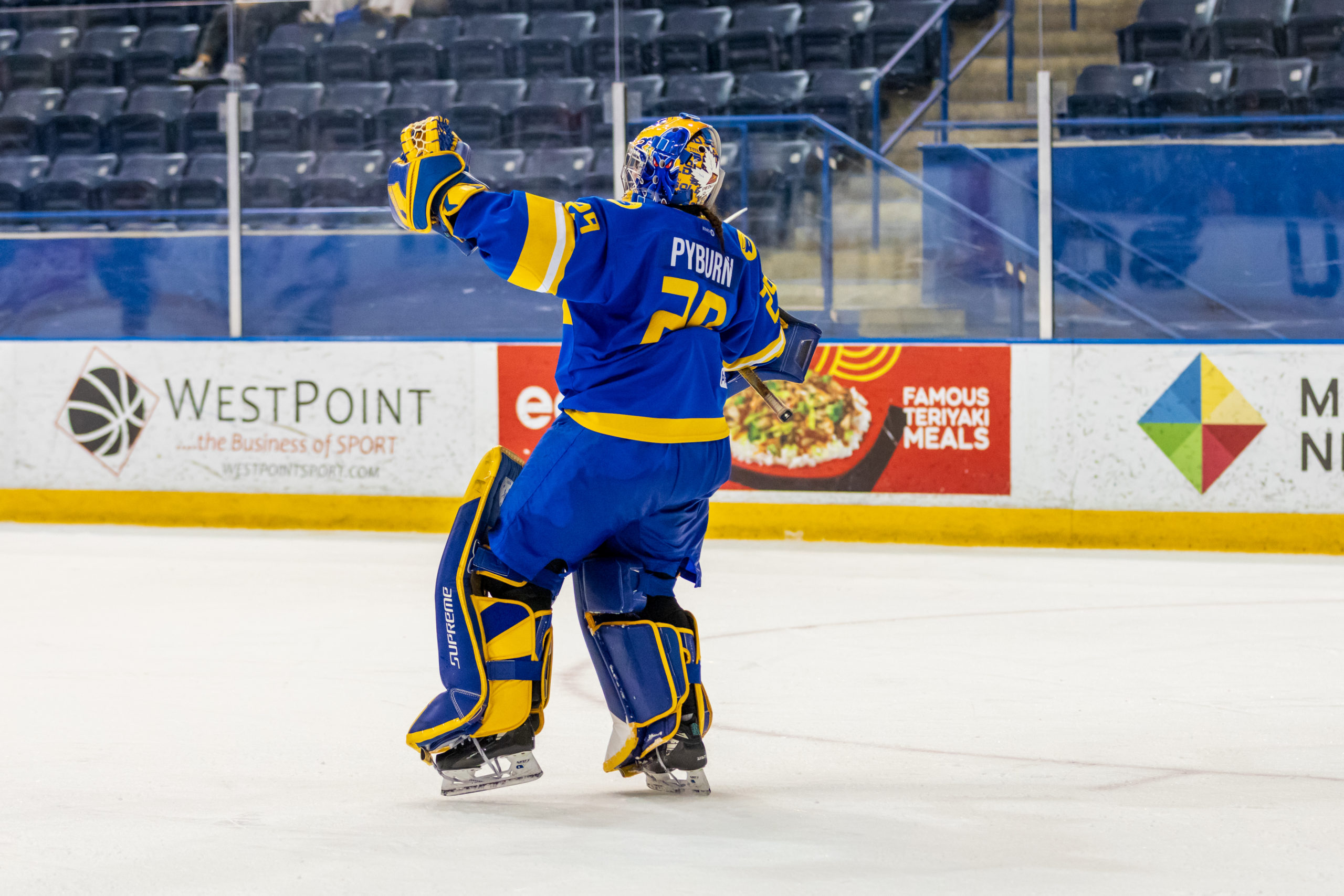 Sydney Pyburn with her arms spread standing in front of the net at the Mattamy Athletics Centre