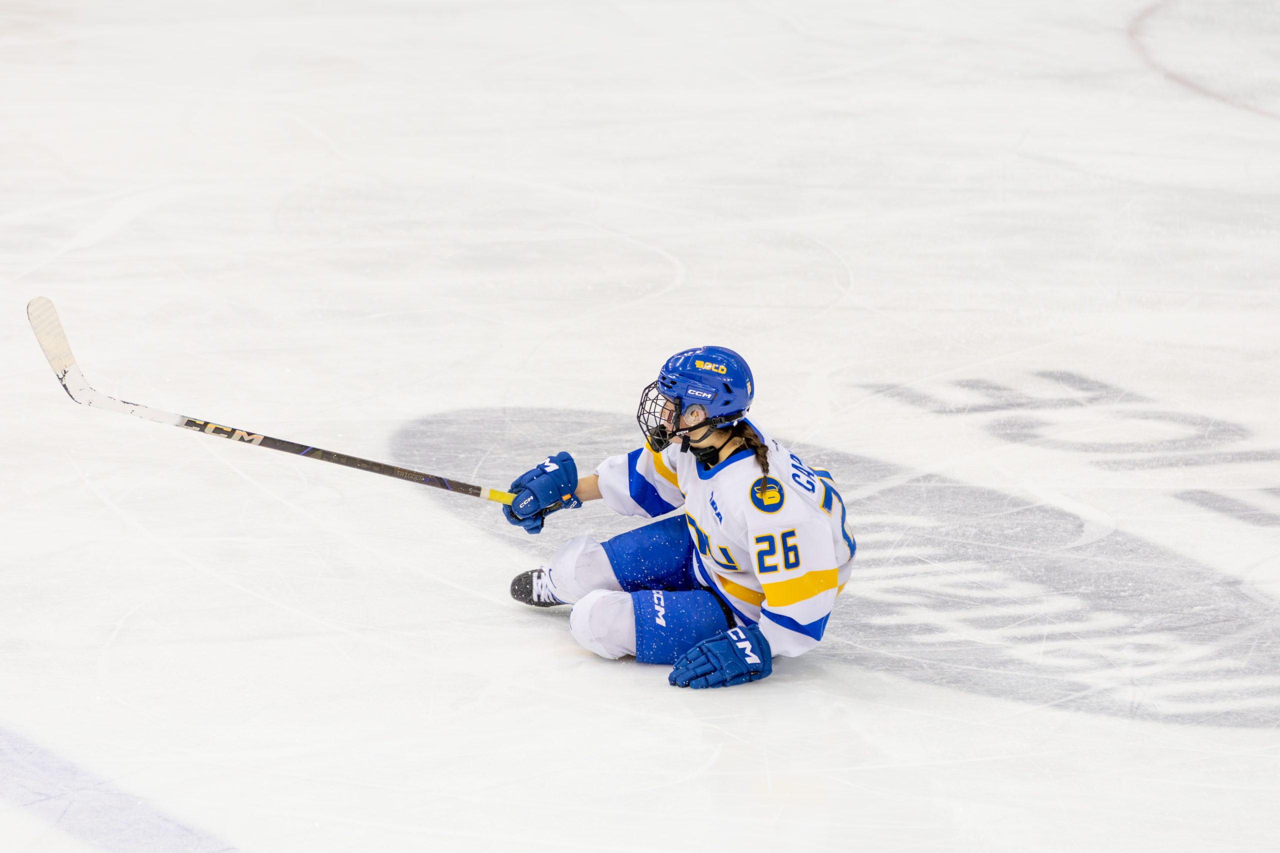 A TMU player tries to get up from the ice