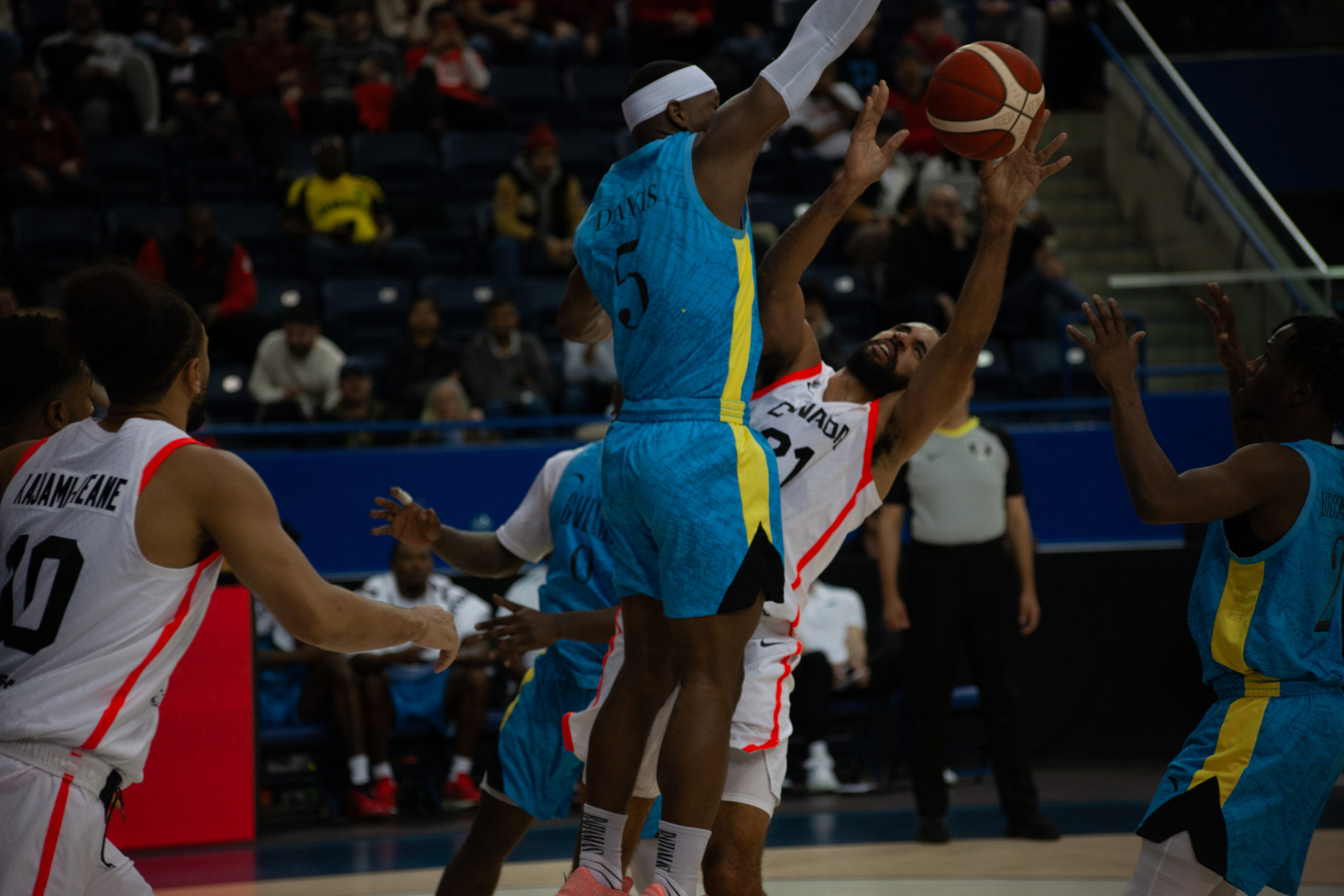 A Canadian basketball player and a Bohemian basketball player collide during a play