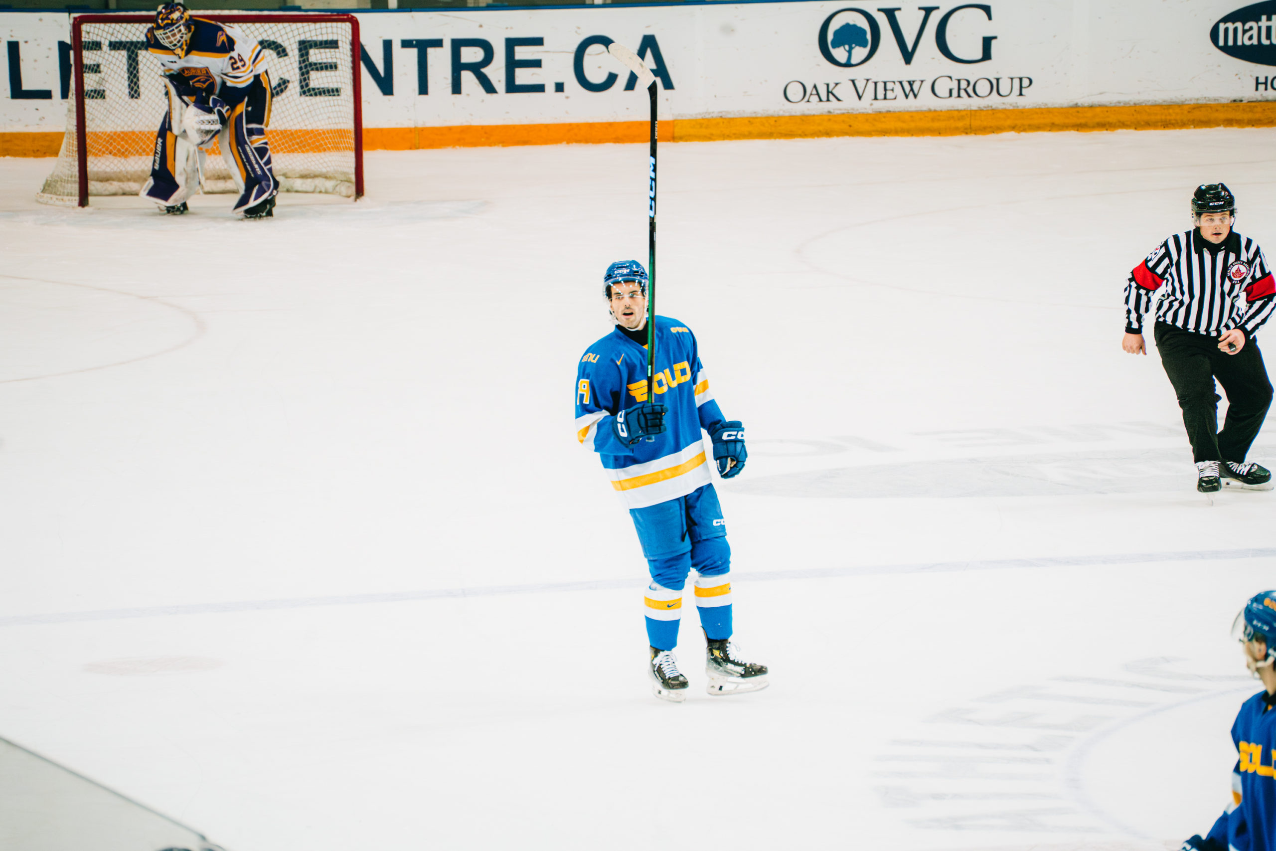 TMU Bold men's hockey player raising his stick in the middle of the ice at the Mattamy Athletic Centre