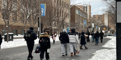 Image of many people walking down Gould street in the snow.