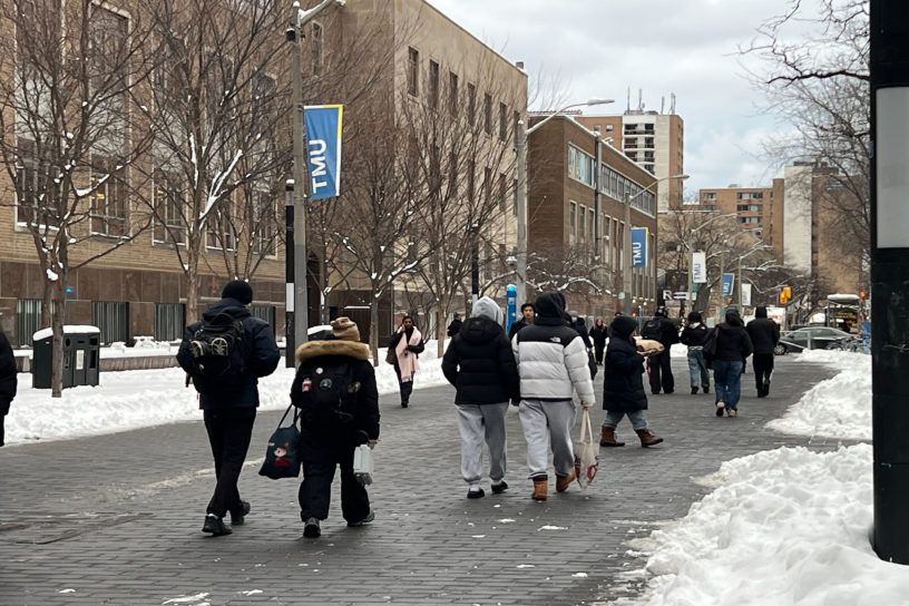 Image of many people walking down Gould street in the snow.