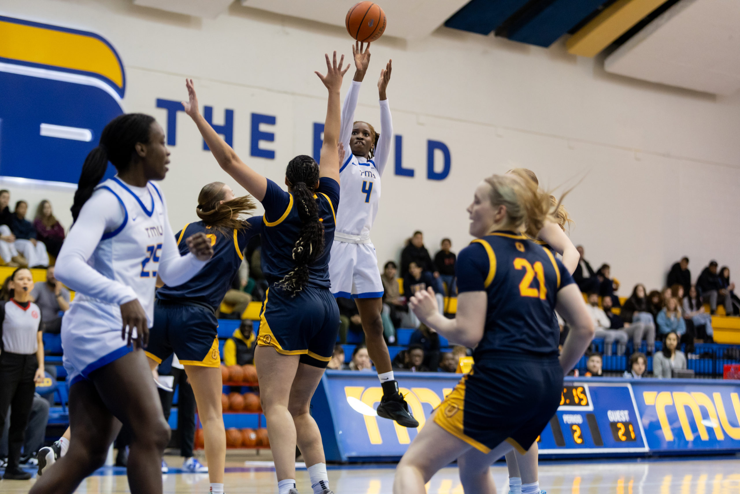 TMU attempts a shot amidst multiple Queen's defenders