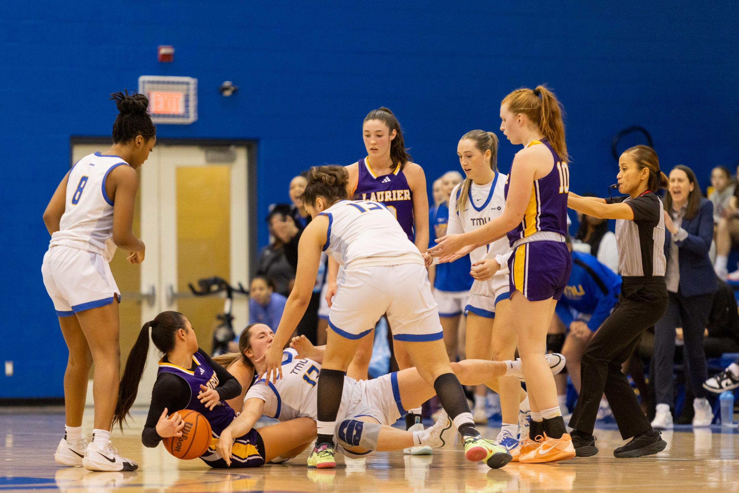 TMU and Laurier players hit the ground battling for possession