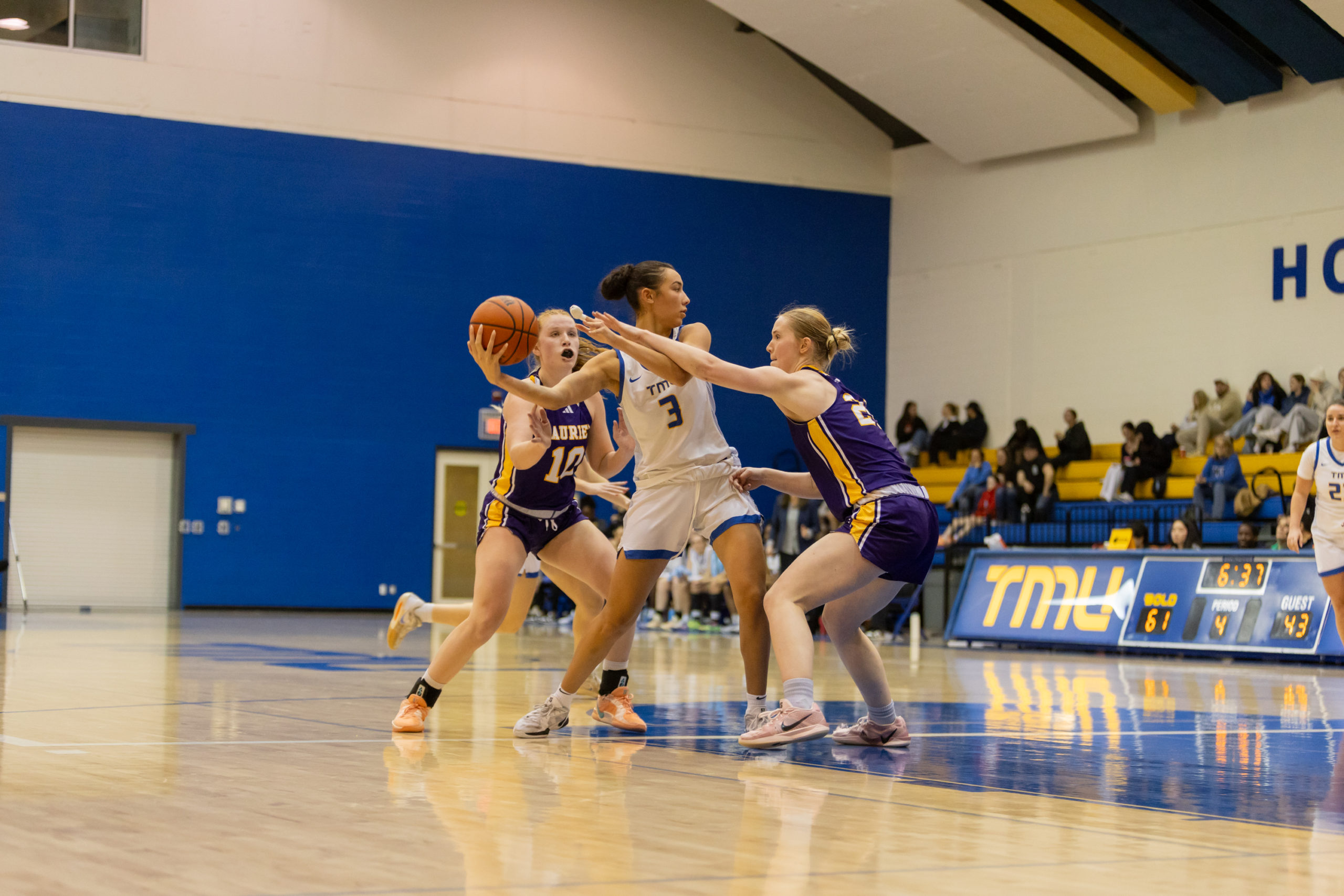 Hailey Franco DeRyck attempts to maintain possession amidst Laurier defenders