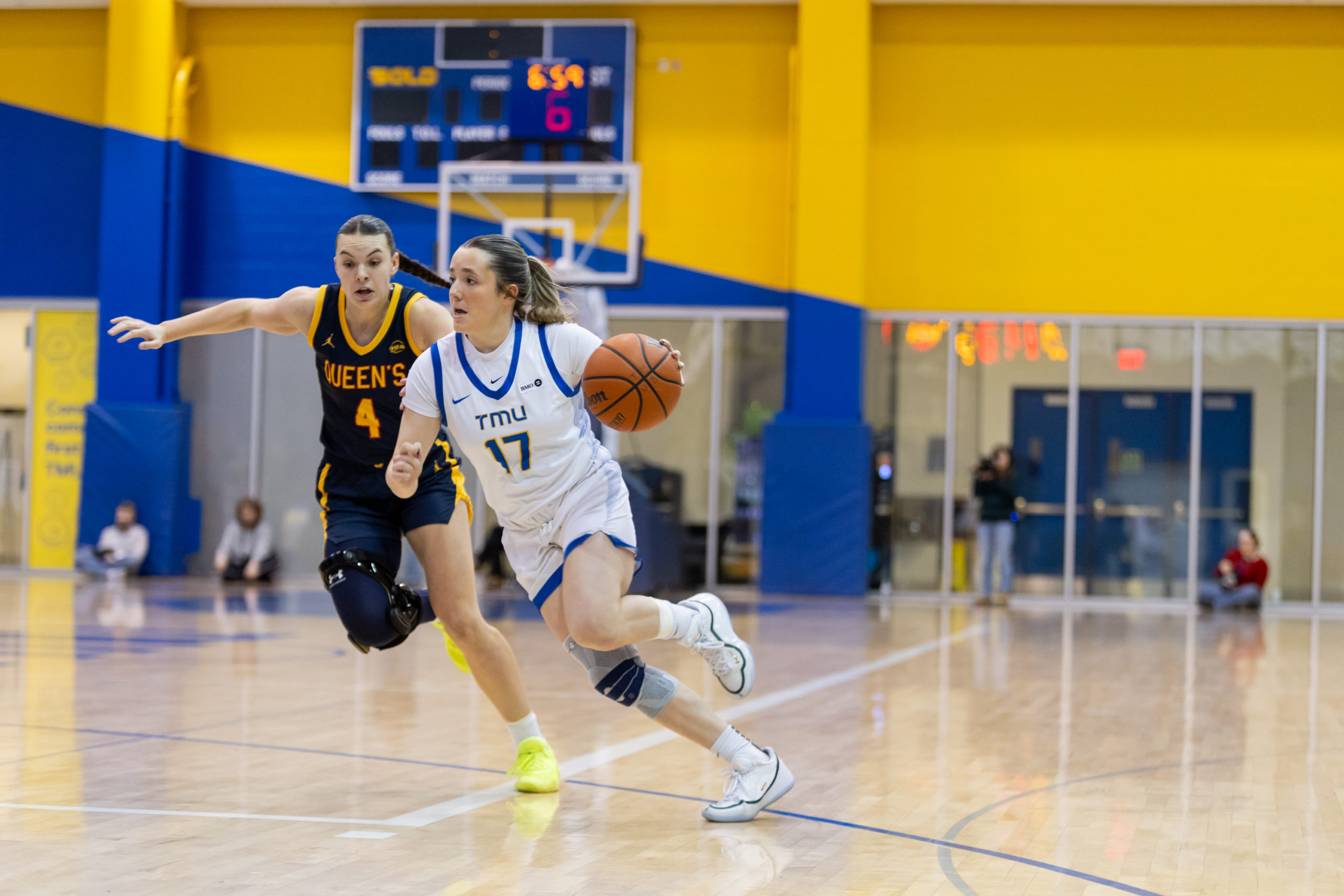 TMU maintains possession amidst a Queen's defender