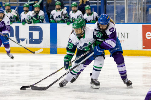A TMU women’s hockey player and a Nipissing player fight for possession of the puck at the Mattamy Athletic Centre