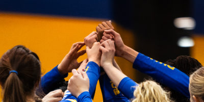 TMU puts their hands together in victory