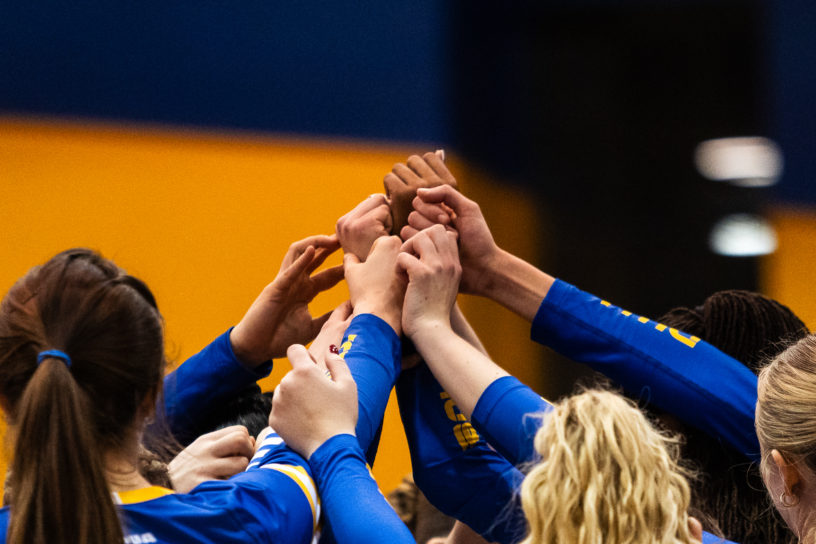 TMU puts their hands together in victory