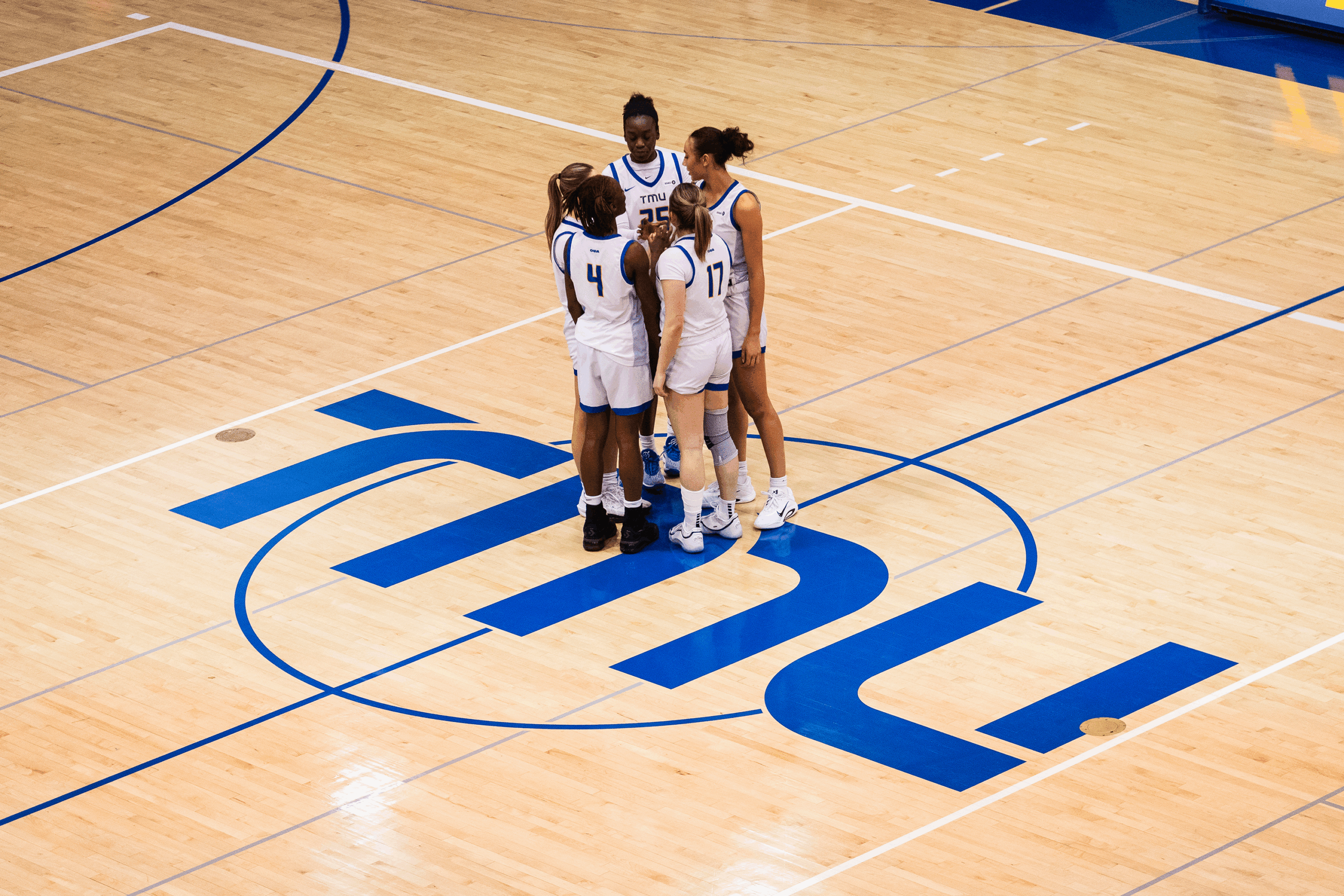 TMU's starting lineup huddles together pre-game