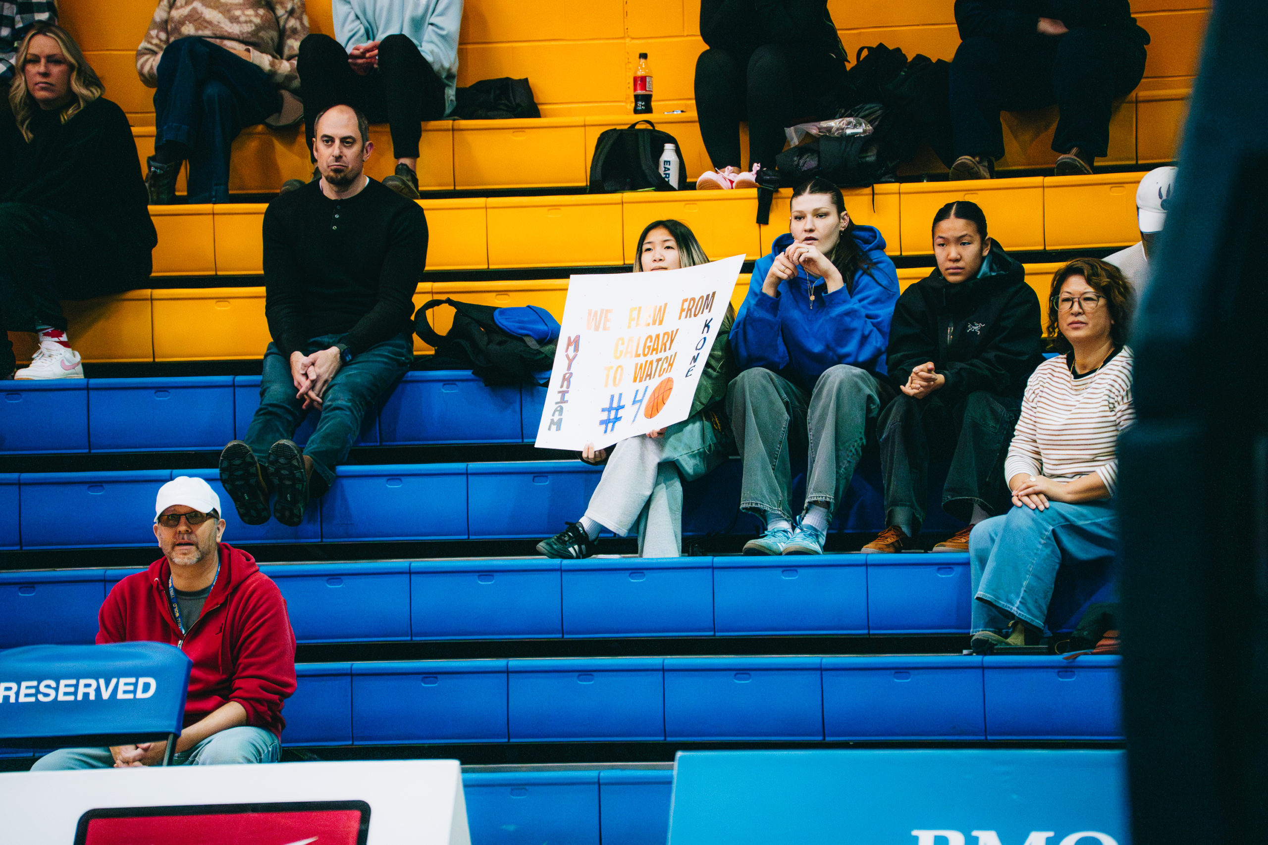 A group of fans in the stands hold up a poster for Myriam Kone