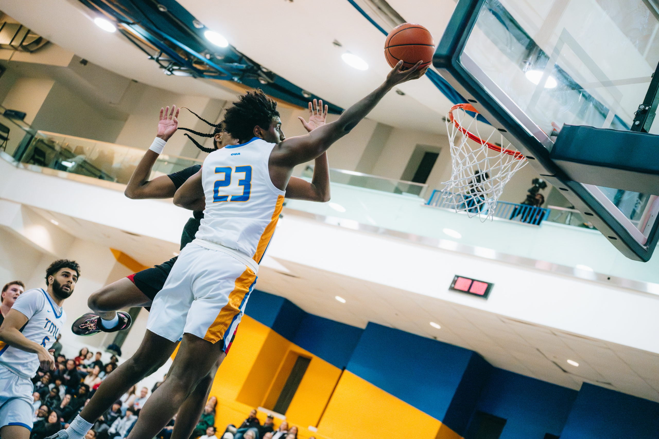 A TMU player makes a shot amidst a Guelph defender trying to block it