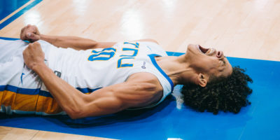 A TMU player celebrates a point while lying on the ground