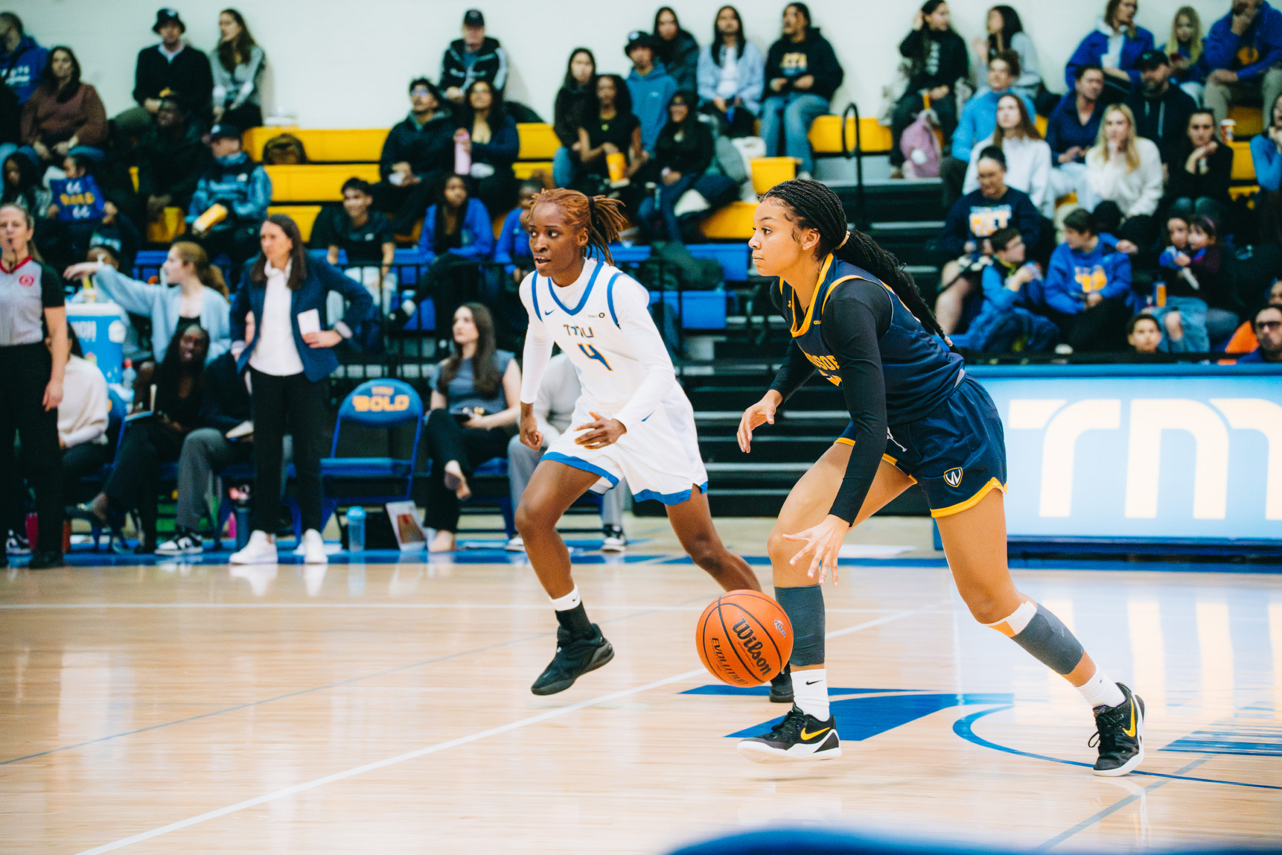 As Windsor maintains possession, a TMU player looks across the court