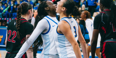 Two TMU players bump chests in celebration