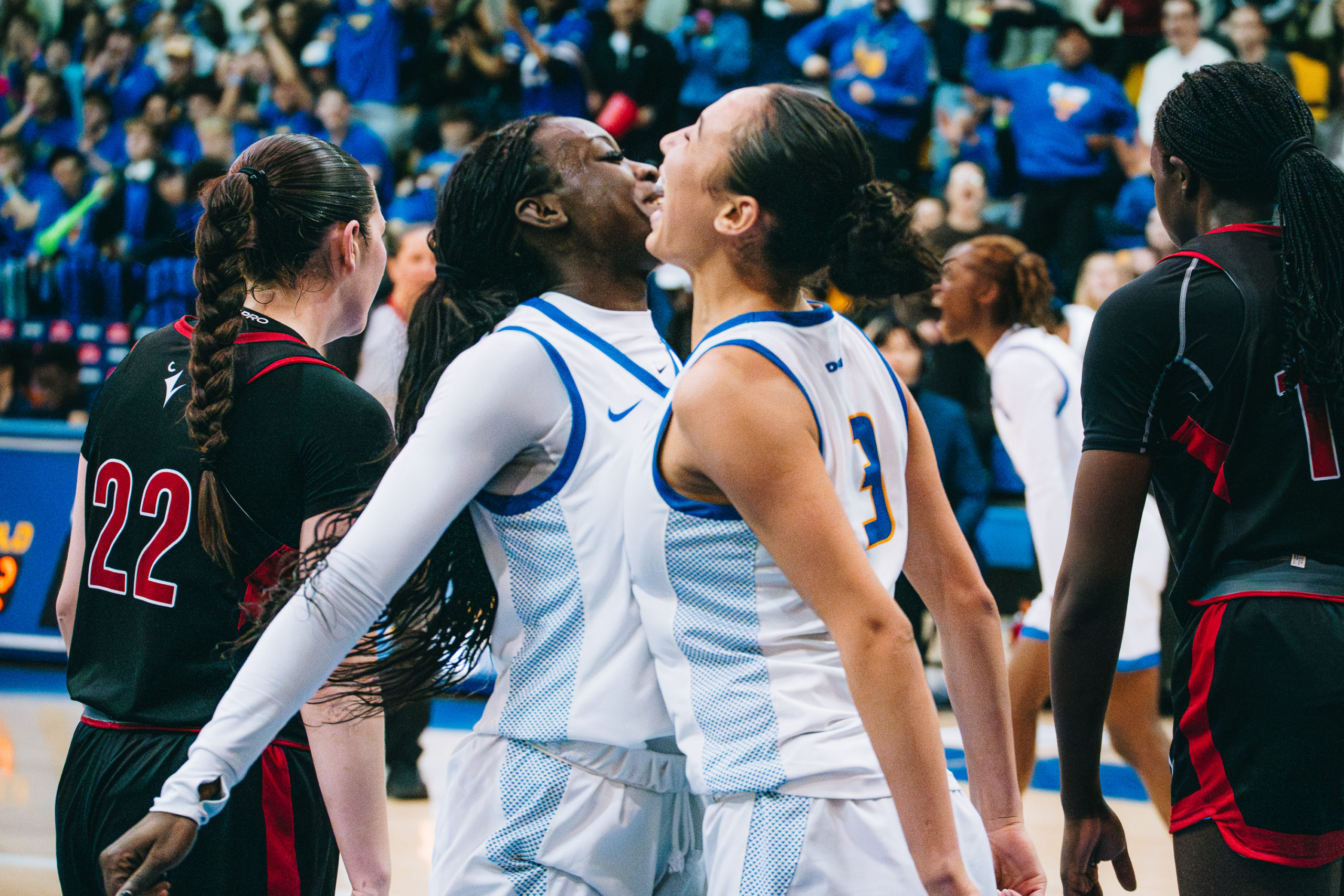 Two TMU players bump chests in celebration