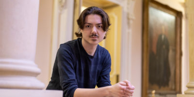 Edward Lander leans against a railing at Osgoode Hall.
