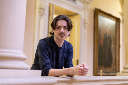 Edward Lander leans against a railing at Osgoode Hall.