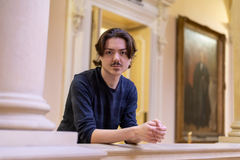 Edward Lander leans against a railing at Osgoode Hall.