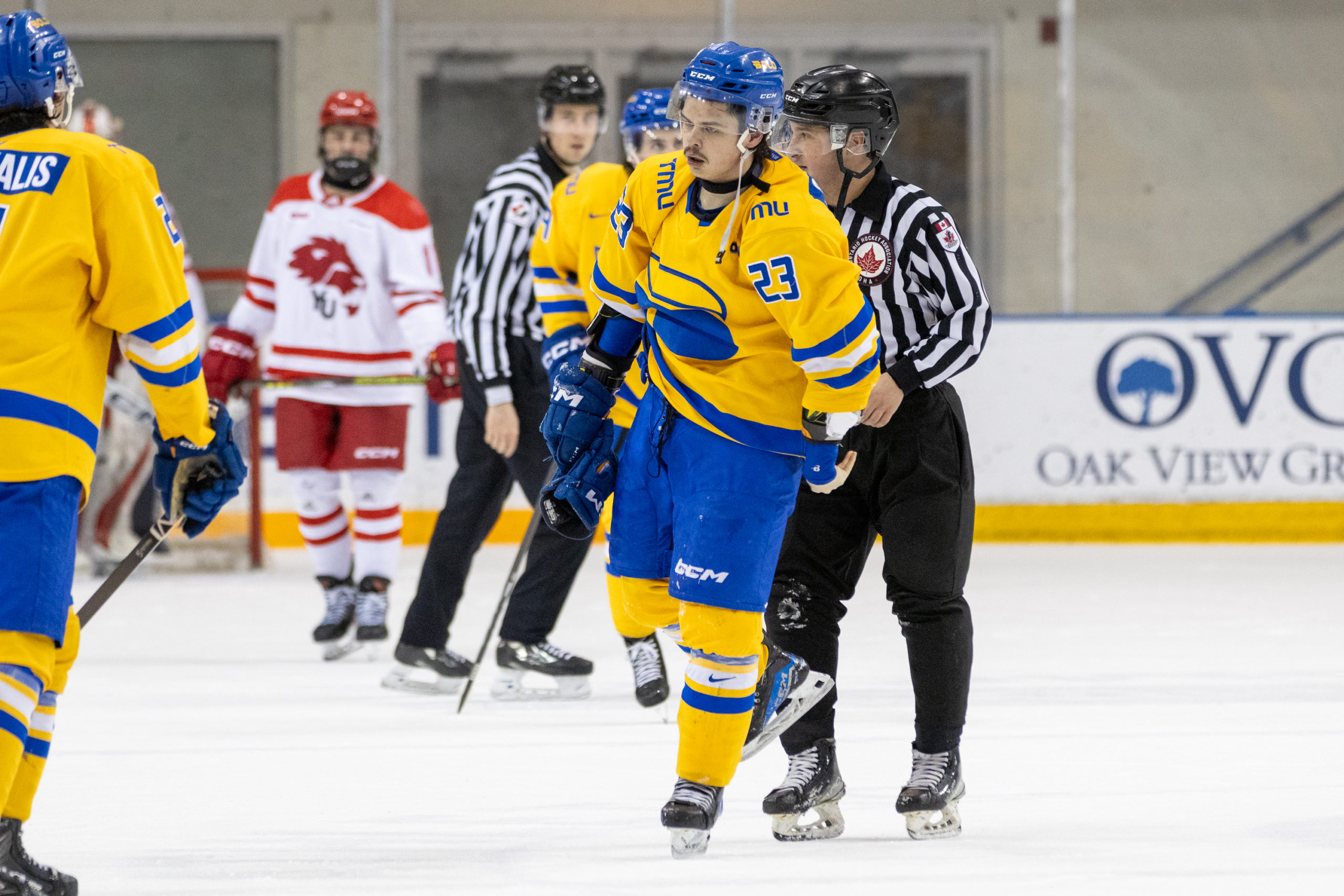 Spencer Shugrue is handled by referees, being led away from a scrum