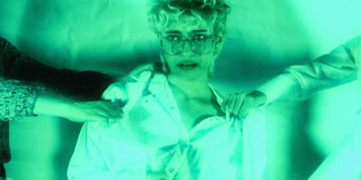 A person in a medical lab coat is getting tugged on my two people pulling them in opposite directions.