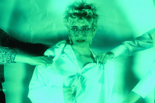 A person in a medical lab coat is getting tugged on my two people pulling them in opposite directions.