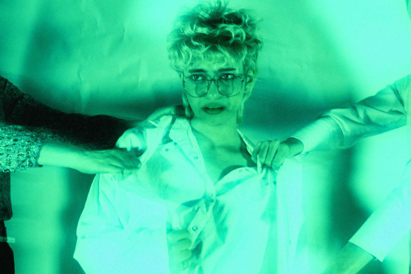 A person in a medical lab coat is getting tugged on my two people pulling them in opposite directions.