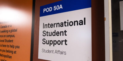 A photo of a sign that reads "POD 50A" "International Student Support" "Student Affairs"