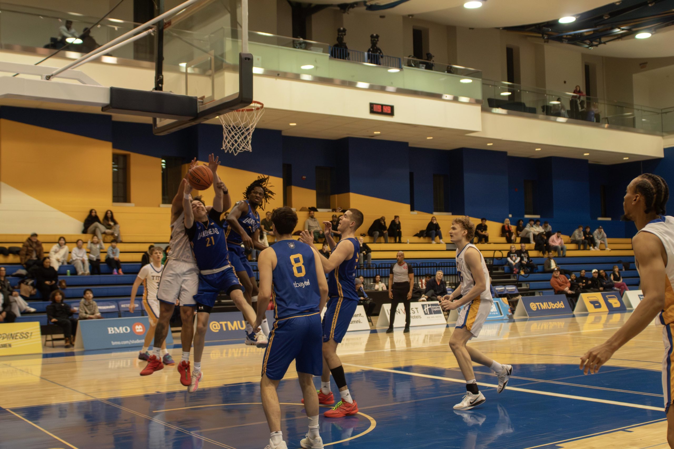 Lakehead men's basketball player goes up for a contested layup at the Mattamy Athletic Centre