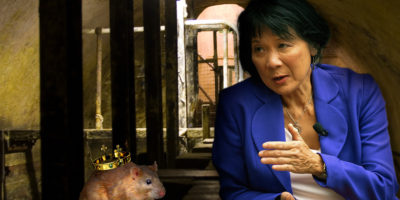 Olivia Chow positioned to be speaking to a mouse with a crown on its back inside the sewer.