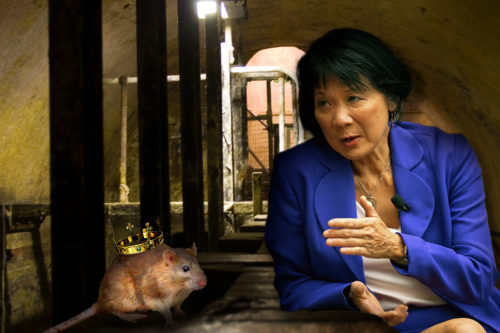 Olivia Chow positioned to be speaking to a mouse with a crown on its back inside the sewer.