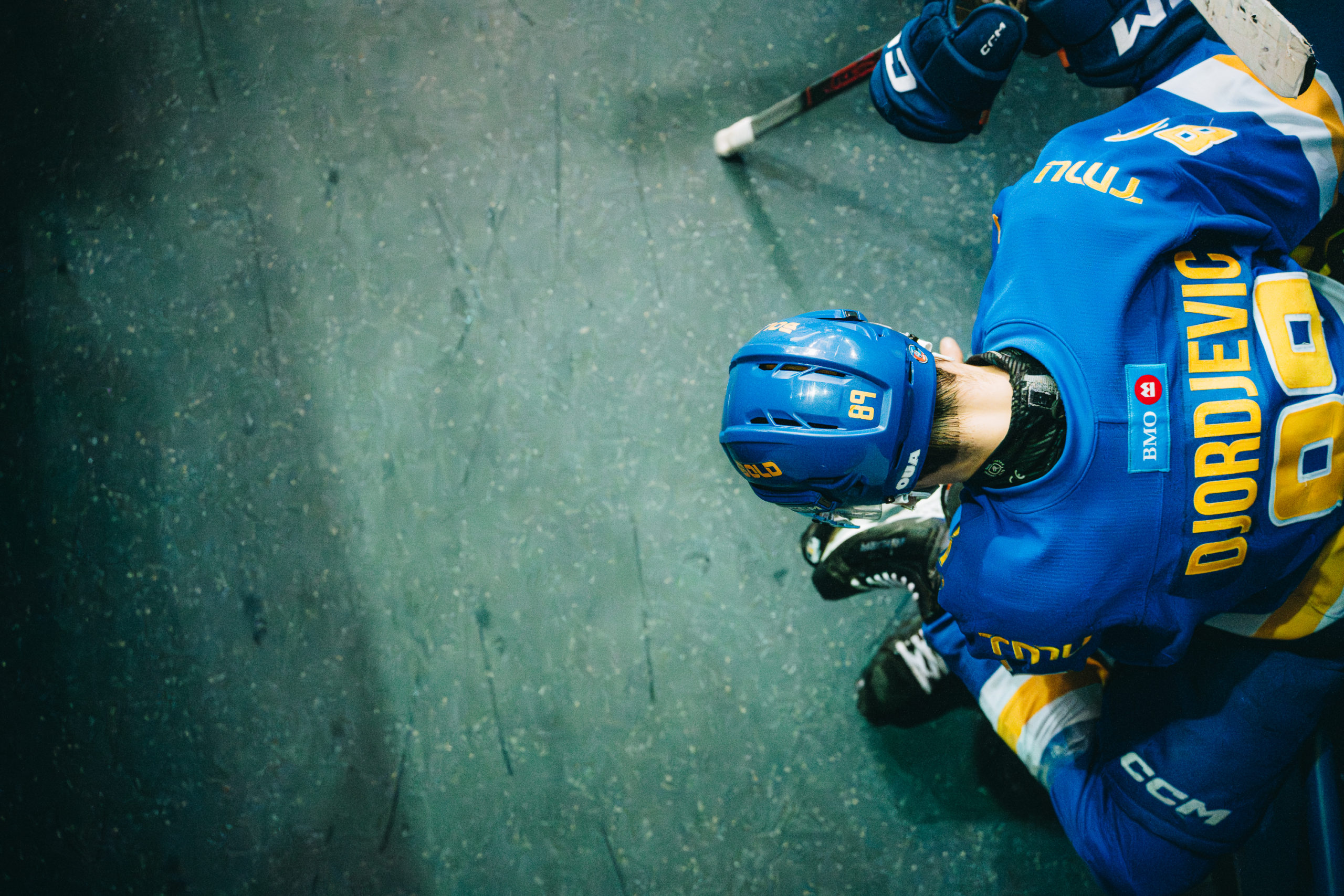 A TMU player leans against a wall outside of the tunnel