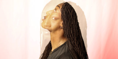 A double exposure image of a woman looking up and looking towards the camera in front of a pink and while background.