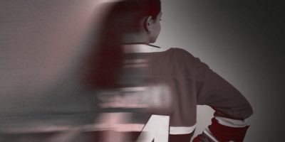 An image of the back of a woman wearing a hockey jersey, with half of the image blurred.